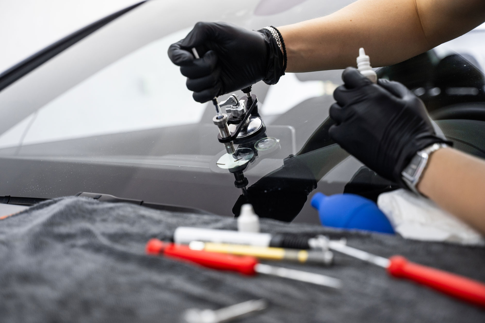 Rock-chip-repair Technician repairing a rock chip on a windshield